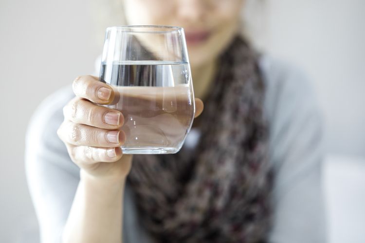 Mladá žena držící sklenici s vodou