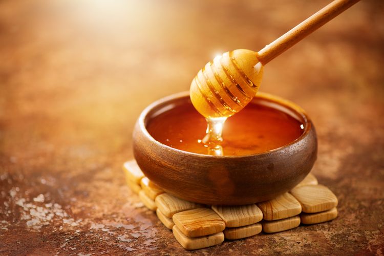 Zlatavý med v hnědé nádobě